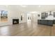 Open-concept living room with hardwood floors, a fireplace, and views into the kitchen at 89 Jumper St, Wendell, NC 27591