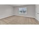 Neutral bedroom featuring plush carpeting, a large window with blinds, and a white door at 107 Wilderness Ct, Mebane, NC 27302