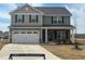 Charming two-story home features a two-car garage, stone accents, and a well-manicured lawn at 107 Wilderness Ct, Mebane, NC 27302