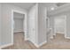 Hallway featuring neutral carpet flooring, white trim, and an open laundry area at 107 Wilderness Ct, Mebane, NC 27302