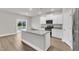 Contemporary kitchen featuring an island with granite countertops, stainless steel appliances, and backyard access at 107 Wilderness Ct, Mebane, NC 27302