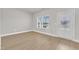 Bright, empty living space with wood-look flooring, a large window, and a white door at 107 Wilderness Ct, Mebane, NC 27302