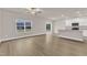 Bright living room with large window and sliding glass doors, adjacent to a modern white kitchen at 107 Wilderness Ct, Mebane, NC 27302