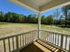Covered back porch with wooden deck overlooking a green landscape at 19 Covey Rise Way, Lillington, NC 27546