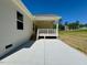 View of covered back porch with steps to an outdoor patio and grassy lawn at 19 Covey Rise Way, Lillington, NC 27546