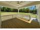Inviting back porch features a wooden deck and a ceiling fan overlooking a big yard at 19 Covey Rise Way, Lillington, NC 27546