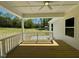 Cozy back porch with white railings, ceiling fan, and serene view of the expansive yard at 19 Covey Rise Way, Lillington, NC 27546