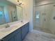 Bathroom featuring double sink vanity, glass shower and soaking tub with tile surround at 19 Covey Rise Way, Lillington, NC 27546