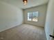 Bright, carpeted bedroom features a window with natural light and neutral-toned walls at 19 Covey Rise Way, Lillington, NC 27546