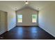 Spacious bedroom featuring vaulted ceiling, wood floor, a ceiling fan and two well-lit windows at 19 Covey Rise Way, Lillington, NC 27546