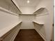 Spacious walk-in closet with ample shelving and dark wood flooring at 19 Covey Rise Way, Lillington, NC 27546