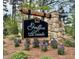 Stone community sign entrance surrounded by lush greenery and flowering plants at 19 Covey Rise Way, Lillington, NC 27546