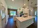 A kitchen island features a white countertop, pendant lighting, and stainless steel appliances set against a brick wall at 19 Covey Rise Way, Lillington, NC 27546