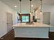 Kitchen island with a white countertop, pendant lights and view of the brick wall and stainless steel appliances at 19 Covey Rise Way, Lillington, NC 27546