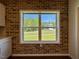 View from kitchen window showcasing brick accent wall and backyard, offering a picturesque view of the property at 19 Covey Rise Way, Lillington, NC 27546