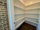 Walk-in pantry with ample white shelving, providing plenty of storage and organization with hardwood floors at 19 Covey Rise Way, Lillington, NC 27546