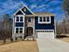 Charming two-story home with a two car garage, stone accents, and blue siding at 222 Grand Griffon Way, Lillington, NC 27546