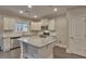 Modern kitchen with white cabinets, granite island, and stainless steel appliances at 222 Grand Griffon Way, Lillington, NC 27546