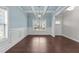 Elegant dining room featuring coffered ceilings, wainscoting, modern light fixture and beautiful hardwood floors at 316 Spruce Pine Trl, Knightdale, NC 27545