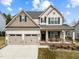 Charming two-story home boasts a two-car garage and inviting front porch with rocking chairs and manicured landscaping at 316 Spruce Pine Trl, Knightdale, NC 27545