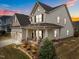 Charming two-story home with covered front porch and two-car garage, enhanced by colorful sunset backdrop at 316 Spruce Pine Trl, Knightdale, NC 27545