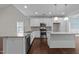 Modern kitchen featuring white cabinets, stainless steel appliances, granite countertops and an island, with dark wood floors at 316 Spruce Pine Trl, Knightdale, NC 27545