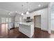 Bright, modern kitchen with stainless steel appliances, white cabinetry, granite countertops and a spacious island at 316 Spruce Pine Trl, Knightdale, NC 27545