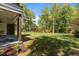 Large grassy backyard featuring a covered patio with stained wood columns and a spacious outdoor area at 339 1/2 Mulberry St, Raleigh, NC 27604