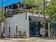 A charming two-story white brick building with a rooftop patio and modern awnings offers a unique urban dining experience at 339 1/2 Mulberry St, Raleigh, NC 27604