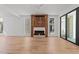 Open-concept living room with a fireplace, hardwood floors, and large windows at 339 1/2 Mulberry St, Raleigh, NC 27604