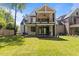 Back exterior with a covered patio, stained wood beams, a balcony, and a well-manicured lawn at 339 1/2 Mulberry St, Raleigh, NC 27604