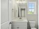 Bright bathroom featuring a white vanity, modern mirror, and a window with a view at 40 Misty Mountain, Spring Hope, NC 27882