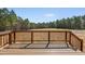 Wooden deck overlooking a serene backyard surrounded by lush trees and vegetation at 40 Misty Mountain, Spring Hope, NC 27882