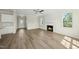 Open-concept living room showcasing hardwood floors, a cozy fireplace, and seamless connection to kitchen and entryway at 40 Misty Mountain, Spring Hope, NC 27882