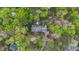 Lush aerial view of a home nestled among trees with a pool and well-manicured landscaping at 5317 Burning Oak Ct, Raleigh, NC 27606