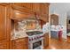 Close-up of a kitchen showcasing a stainless steel range with red knobs and custom backsplash at 5317 Burning Oak Ct, Raleigh, NC 27606