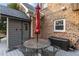 Cozy outdoor patio featuring a metal table with chairs, red umbrella, and storage box near the brick exterior wall at 5317 Burning Oak Ct, Raleigh, NC 27606