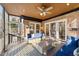 Inviting sunroom with a ceiling fan, brick wall, and comfortable wicker furniture, perfect for enjoying the outdoors indoors at 5317 Burning Oak Ct, Raleigh, NC 27606