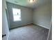A serene bedroom featuring soft carpet, a window for natural light, and a minimalist design at 114 Arundel Dr, Archer Lodge, NC 27527