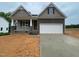 New construction home featuring stone accents, a two-car garage, and a charming covered porch at 114 Arundel Dr, Archer Lodge, NC 27527