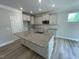 A modern kitchen featuring an island with granite countertops, stainless steel appliances, and wood floors at 114 Arundel Dr, Archer Lodge, NC 27527