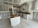 Spacious kitchen under construction featuring white cabinets, center island, and natural light at 114 Arundel Dr, Archer Lodge, NC 27527