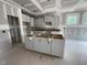 Spacious kitchen under construction featuring white cabinets, center island, and natural light at 114 Arundel Dr, Archer Lodge, NC 27527