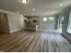 Spacious open-concept living area with kitchen island, wood floors, and abundant natural light at 114 Arundel Dr, Archer Lodge, NC 27527