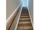 Carpeted stairs with a wooden handrail leading to the upper level of the home at 114 Arundel Dr, Archer Lodge, NC 27527