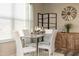 Bright dining room featuring a glass table, white chairs, and a decorative windmill clock at 170 Vega Loop, Sanford, NC 27330