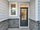 Exterior front door detail with stone and gray wood siding at 203 Pond Vw Ct # 1, Fuquay Varina, NC 27526