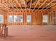 Bright, unfinished living room with wooden framework, multiple windows, and exposed ceiling at 203 Pond Vw Ct # 1, Fuquay Varina, NC 27526