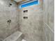 Modern shower with gray tiles, a shower head, a built-in bench, and small window at 203 Pond Vw Ct # 1, Fuquay Varina, NC 27526