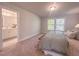 Neutral bedroom featuring a large window with outside view, a queen bed, and an en-suite bathroom at 205 Pond Vw Ct # 2, Fuquay Varina, NC 27526